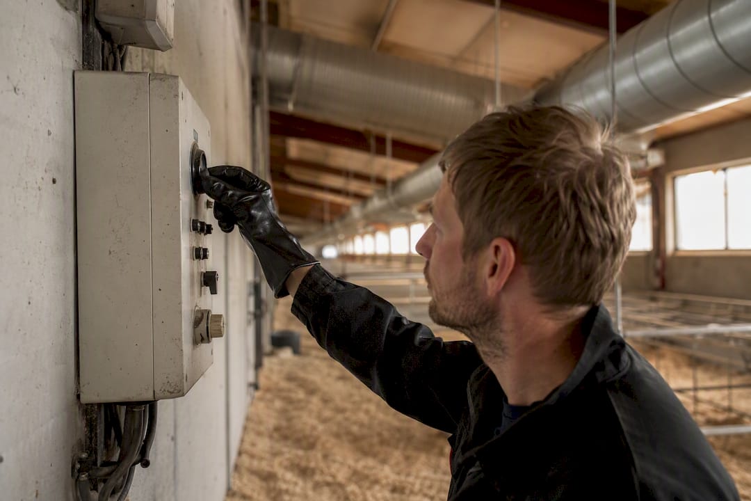 Met de hand wordt het ventilatiesysteem in de stal van het agrarische bedrijf nauwkeurig afgesteld.