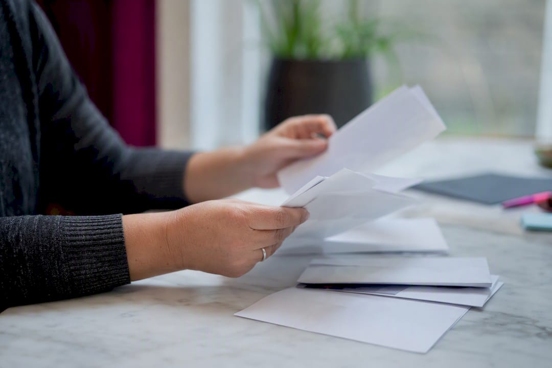 Handen die huishoudelijke rekeningen en kredietdocumenten sorteren
