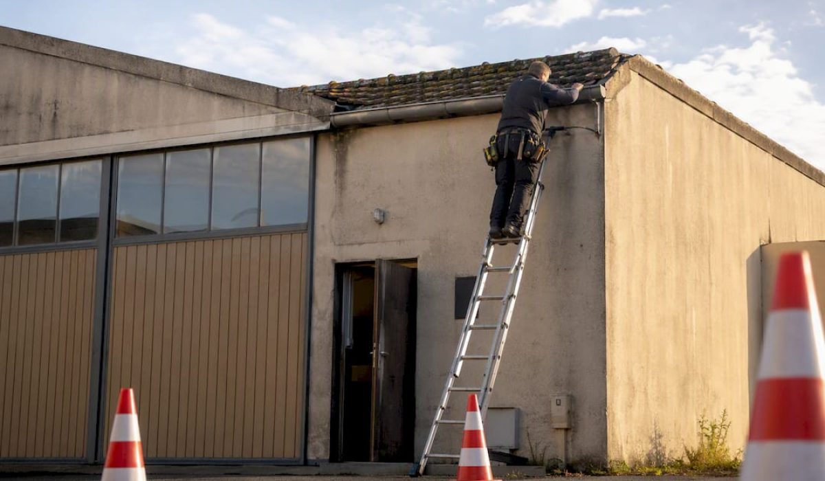 Monteur voert dakreparatie uit aan bedrijfspand