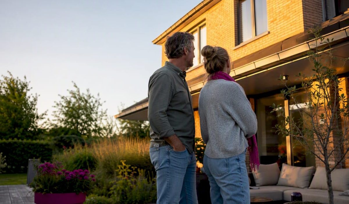 Huiseigenaren bekijken hun huis vanaf het terras